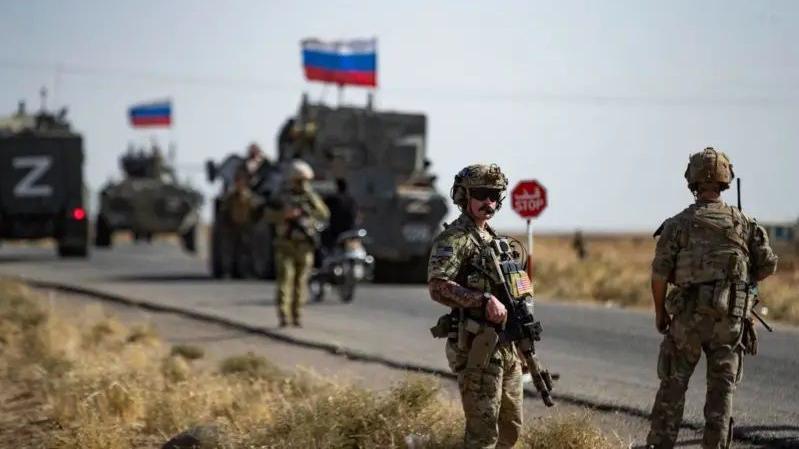 Militares armados em uma via com tanques de guerra com a bandeira russa.