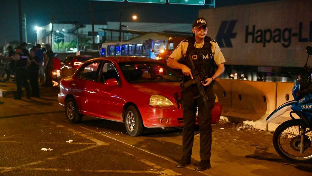 Ecuadorian police guard the car in which the director of Litoral was traveling