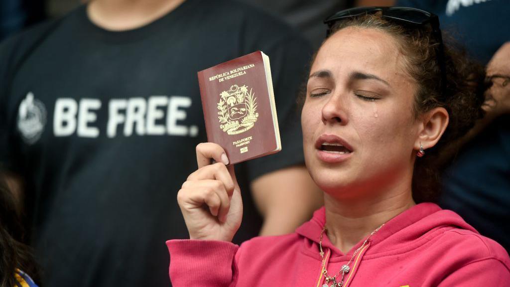 Venezolana sostiene su pasaporte.