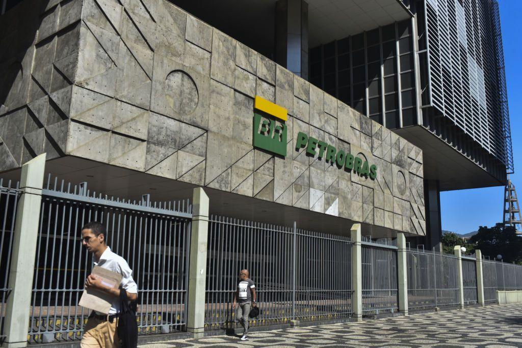 Dois homens na calçada passando em frente à sede da Petrobras