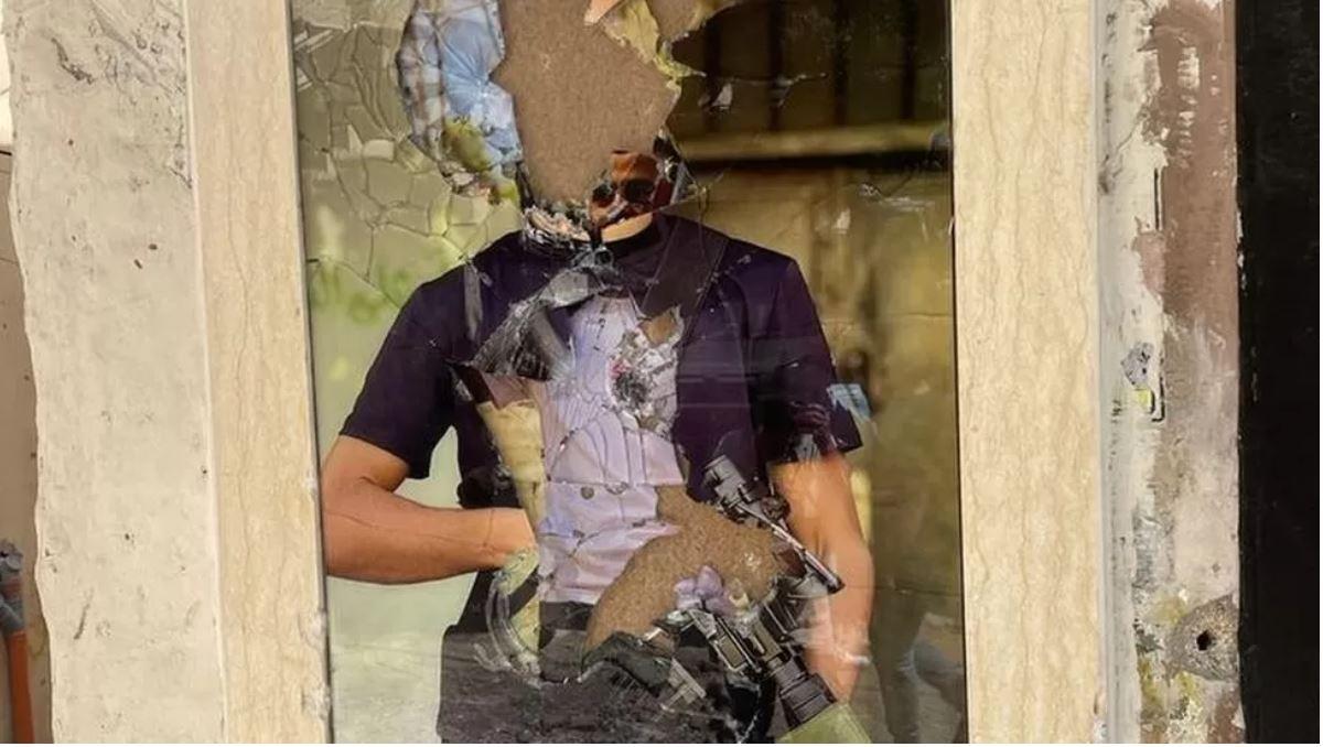 جدار مدمر عليه ملصق لمسلح فلسطيني
