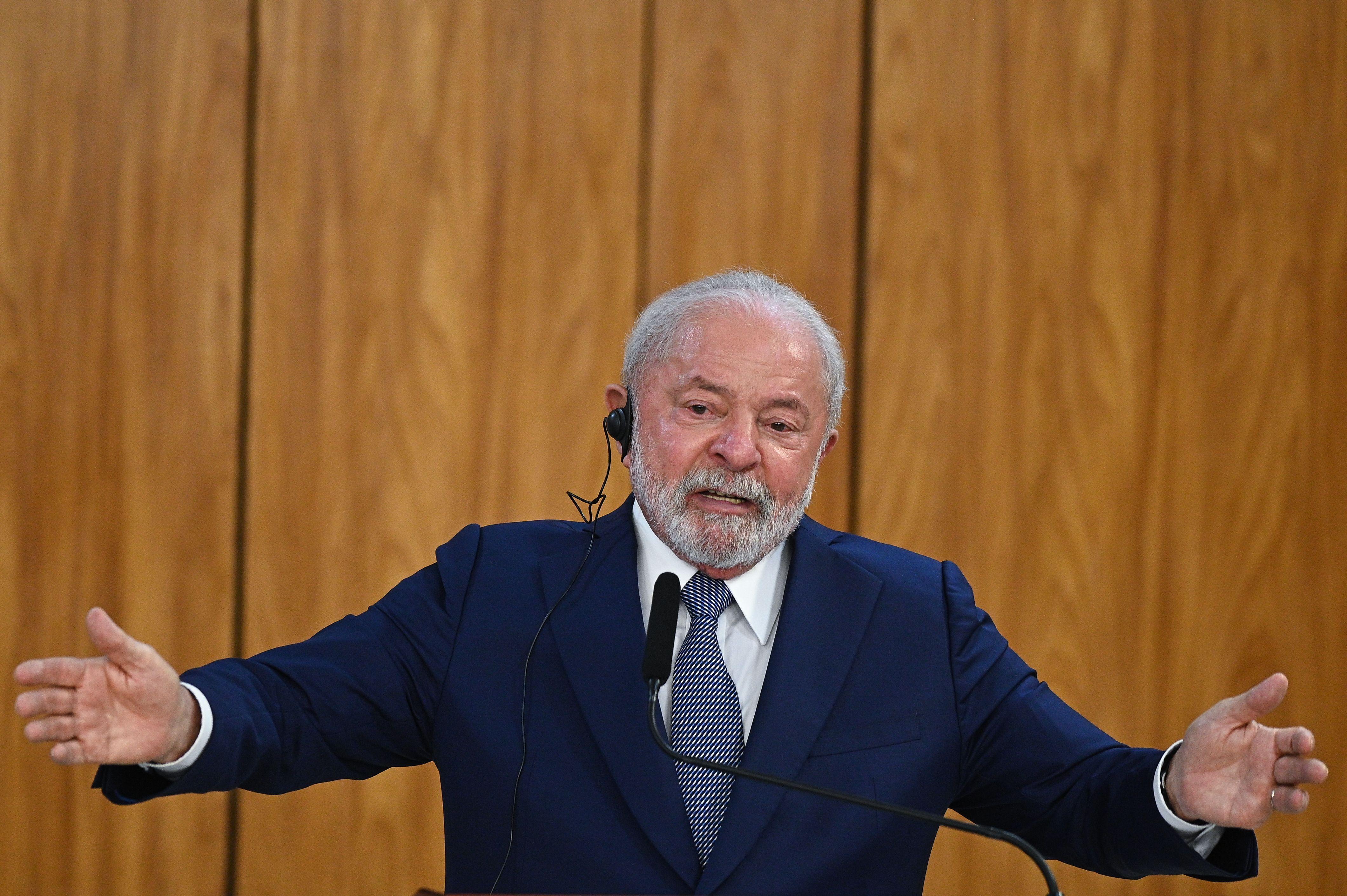 Lula de braços abertos durante discurso em púlpito