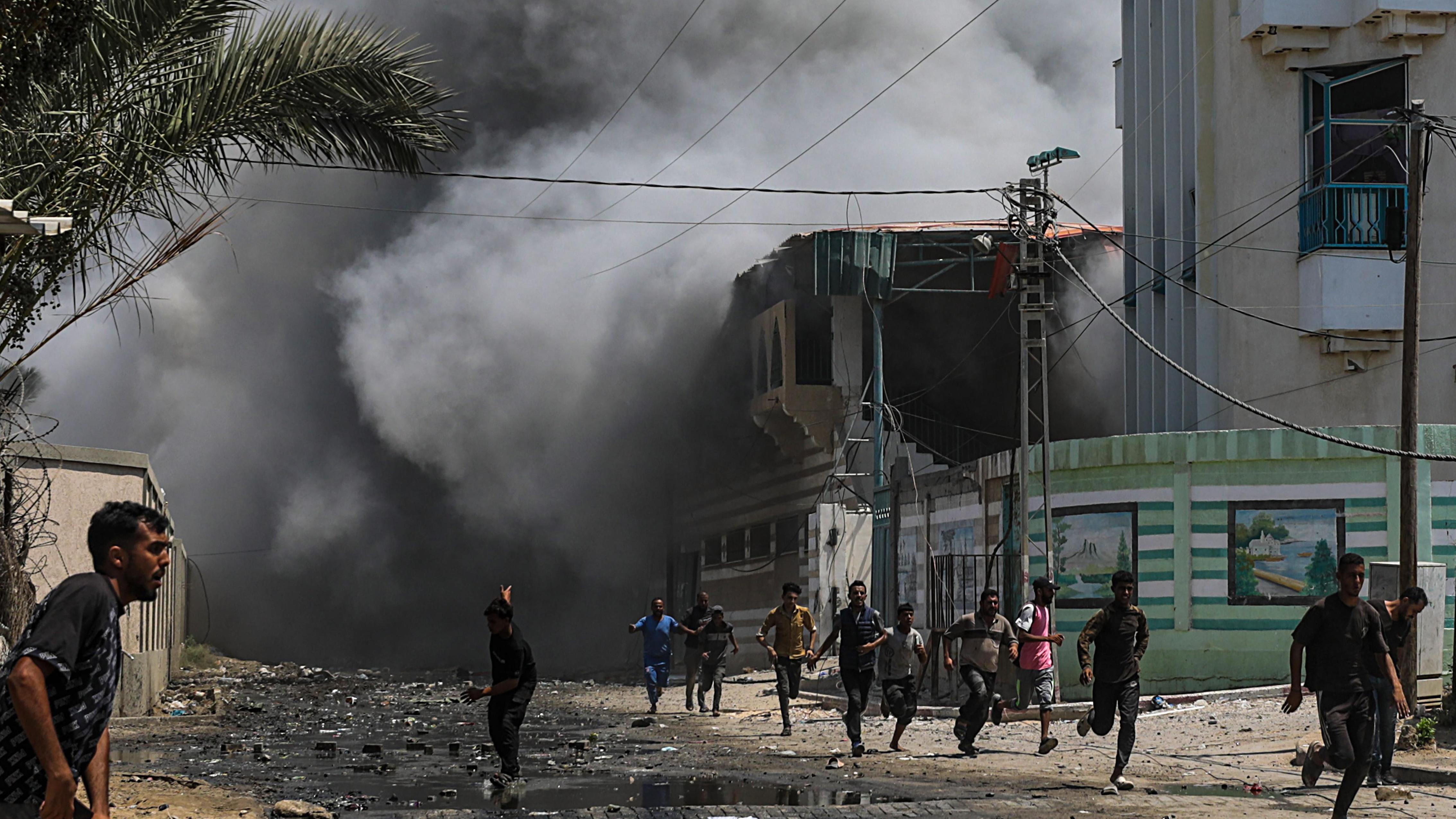 Palestinos corren a esconderse después del ataque contra la escuela.