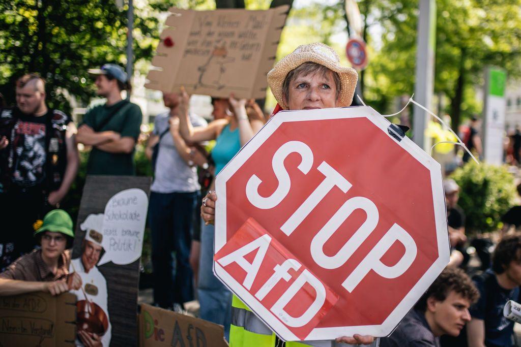 Mulher carrega cartaz em protesto contra o partido AfD