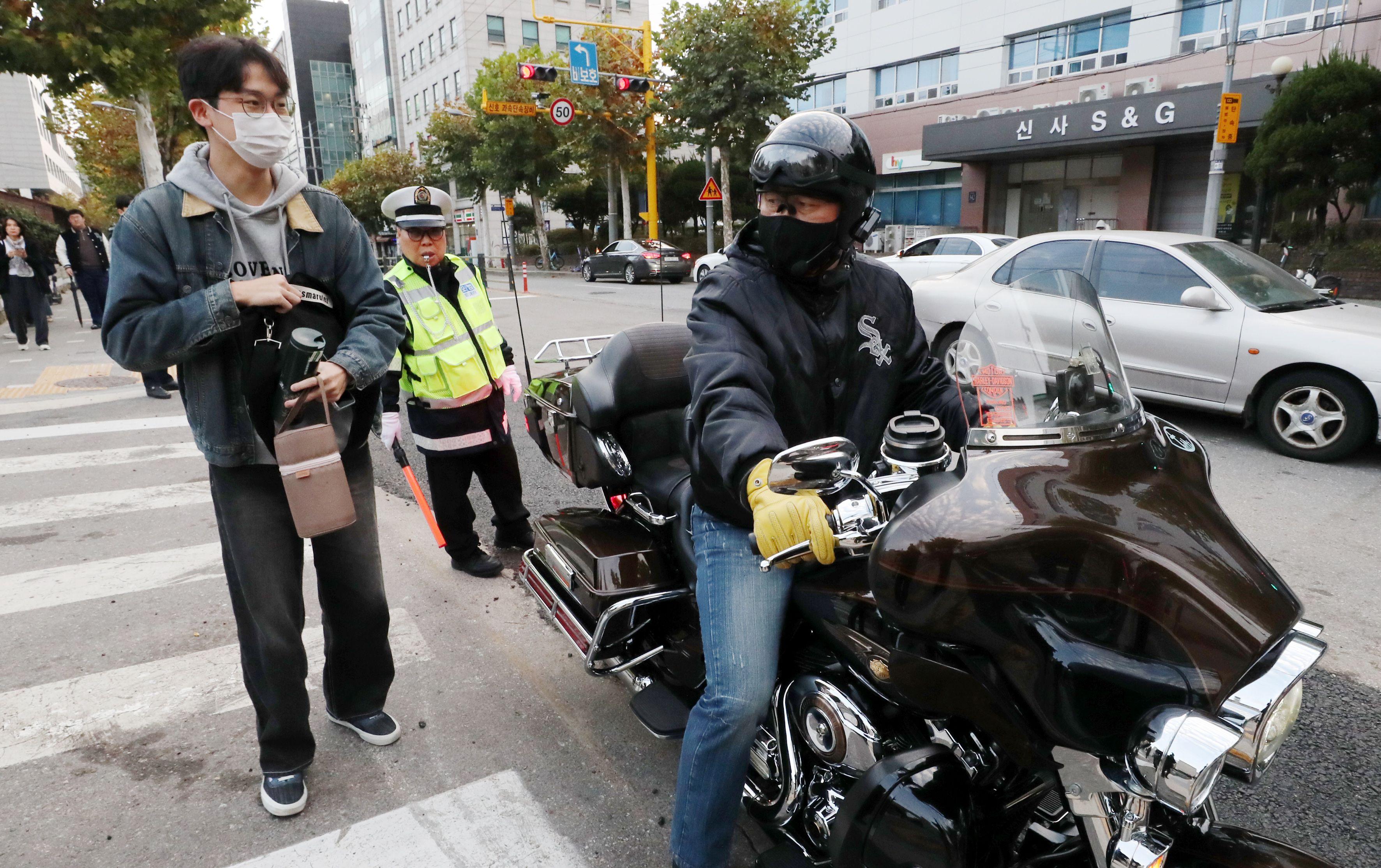 서울 강남구 휘문고등학교 앞에서 한 수험생이 오토바이로 시험장에 태워준 아버지와 입실 전 대화를 나누고 있다