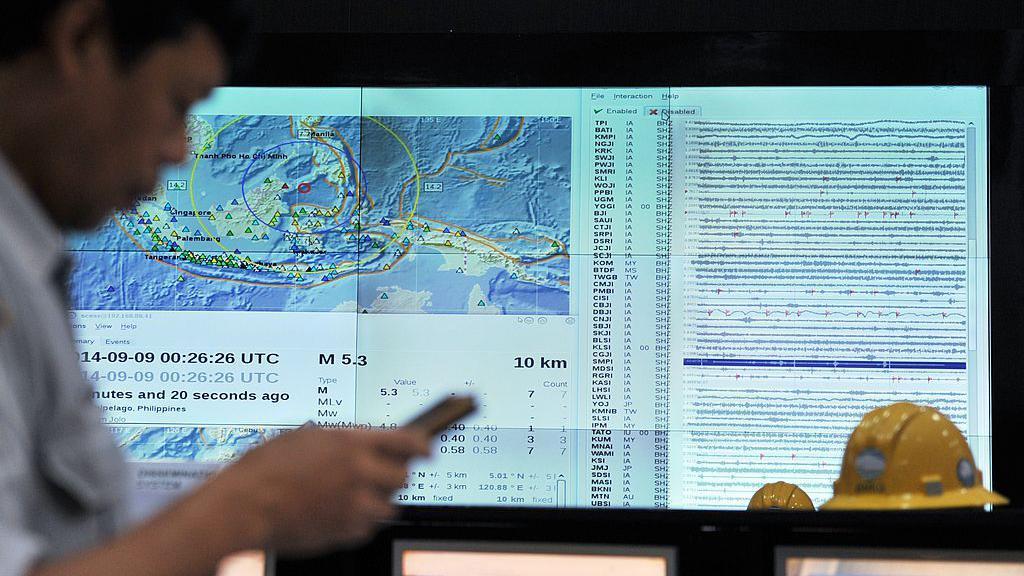 Un funcionario indonesio revisa su teléfono para ver si hay un SMS de alerta de terremoto y tsunami durante un ejercicio de tsunami en todo el Océano Índico.