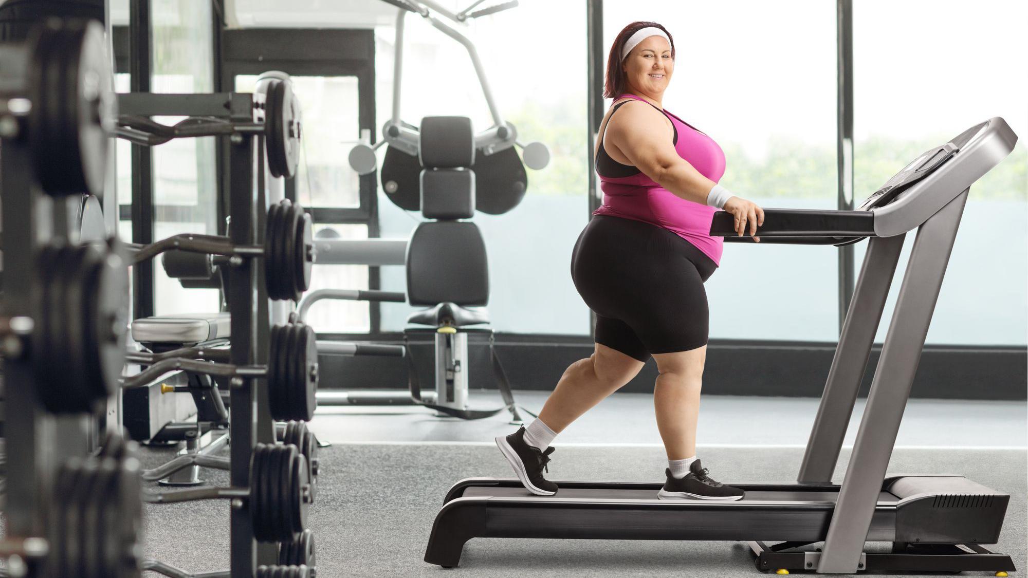 Mujer caminando en la cinta en el gimnasio