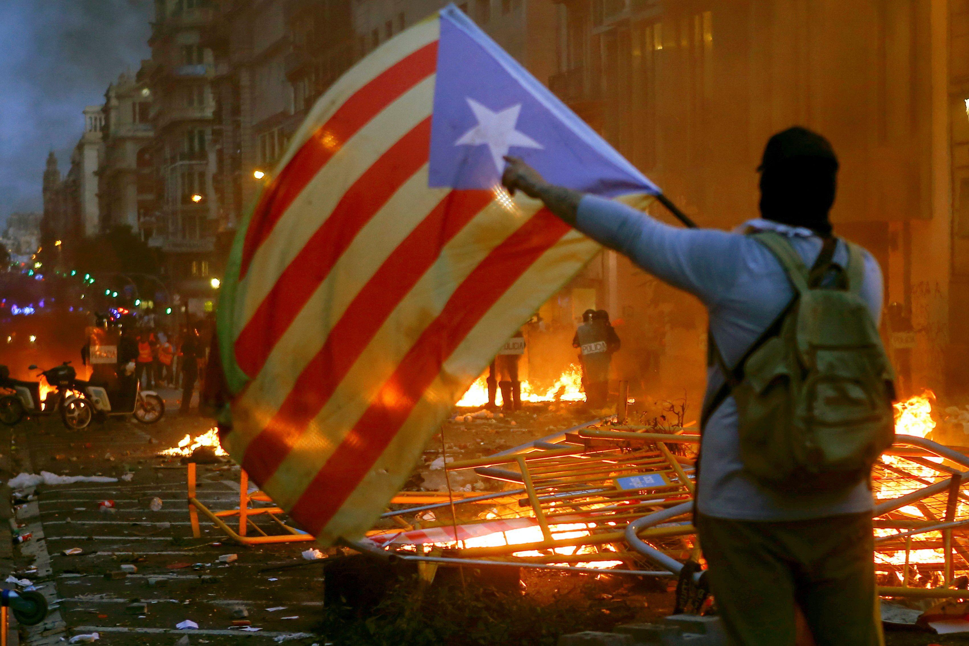 Una persona ondea una bandera independentista catalana en unos disturbios.