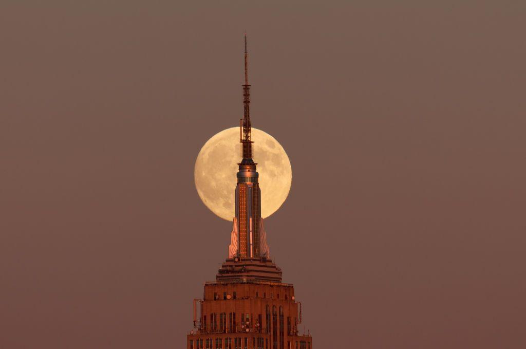 Superlua surgindo atrás do Empire State Building na cidade de Nova York ao anoitecer de 16 de outubro de 2024.