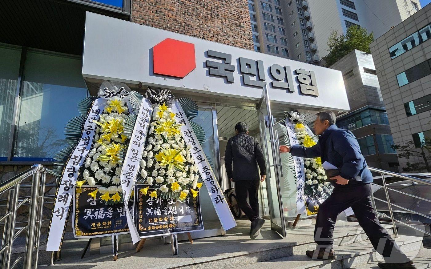 10일 오후 대구 수성구 범어동 국민의힘 대구·경북시·도당 당사 입구에 윤석열 대통령 탄핵안 표결을 거부한 국민의힘을 규탄하는 내용의 근조 화환이 놓여 있다.