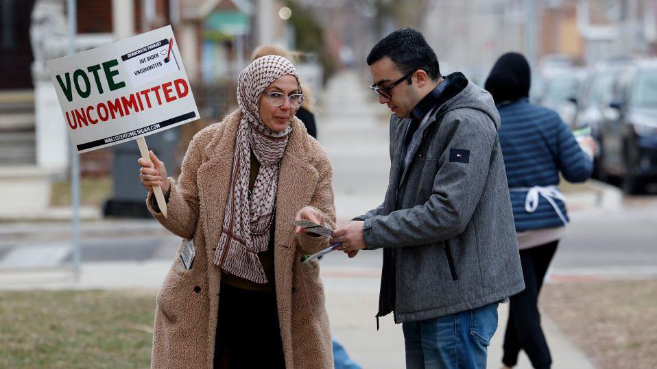 Una mujer con un cartel donde se llama a los votantes a no votar por Biden. 