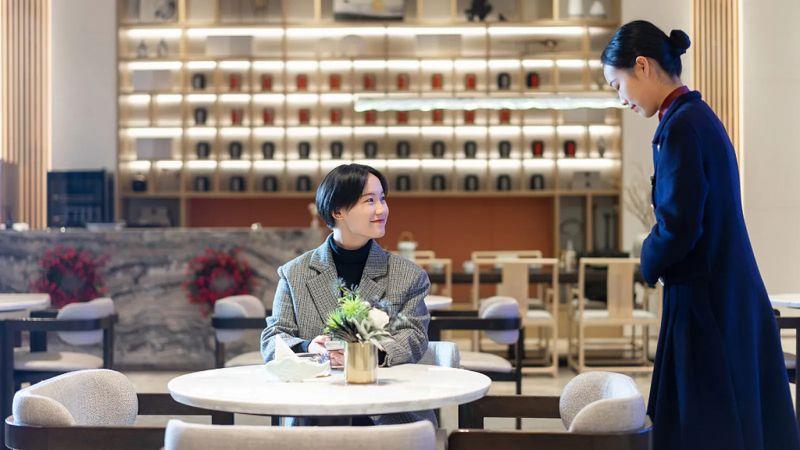 Mulher sendo atendida em restaurante na China