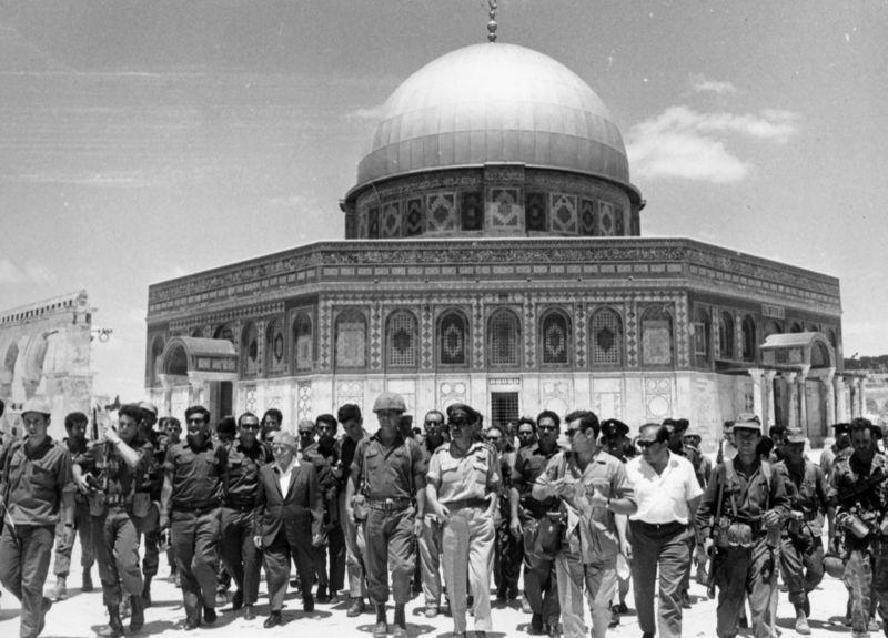 Juni 1967 | David Ben-Gurion (salah satu pendiri Israel) dan Isaac Rabin (Kepala Staf tentara Israel) memimpin sekelompok tentara di depan Dome of the Rock, di wilayah pendudukan Yerusalem.
