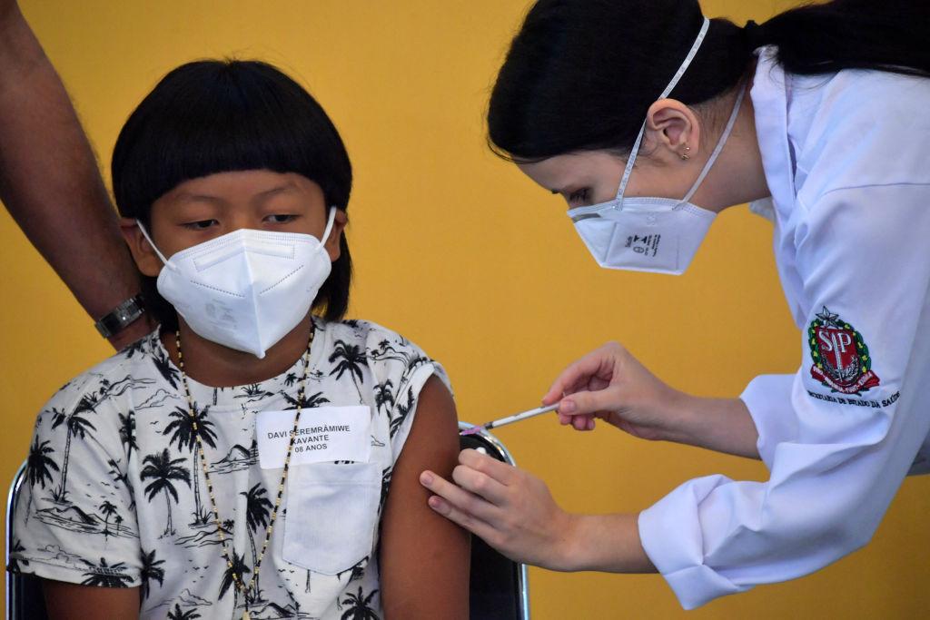 O menino indígena brasileiro Davi Xavante - a primeira criança no Brasil a ser vacinado contra a covid-19 - recebe a primeira dose da vacina Pfizer-BioNTech no hospital Clinicas em São Paulo, Brasil, em 14 de janeiro de 2022. 