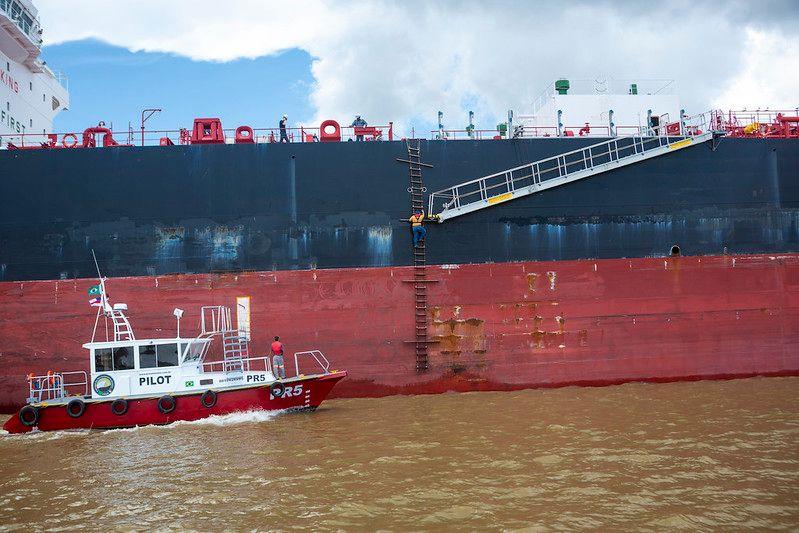 Barco pequeno ao lado de navio grande