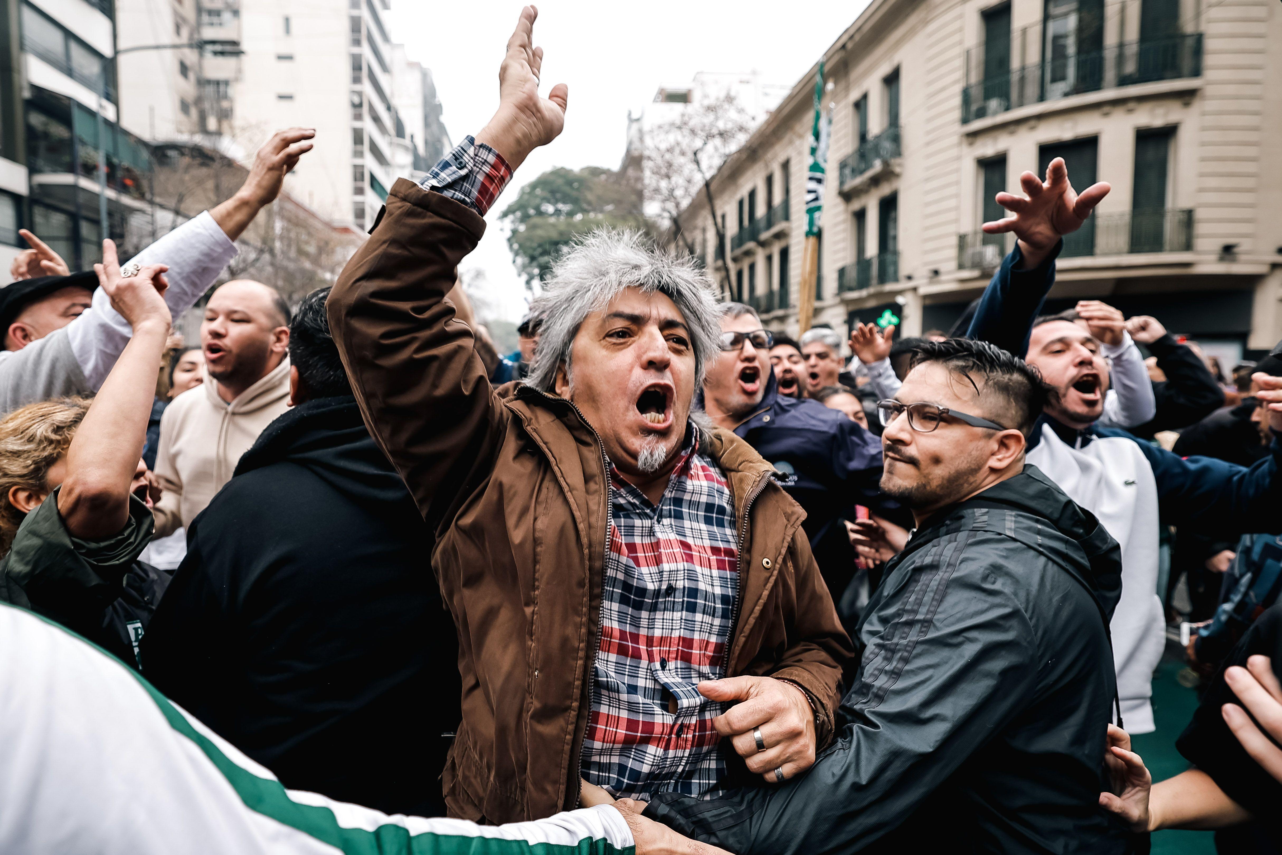 Un hombre grita con el brazo en alto en una protesta contra la reforma de Milei