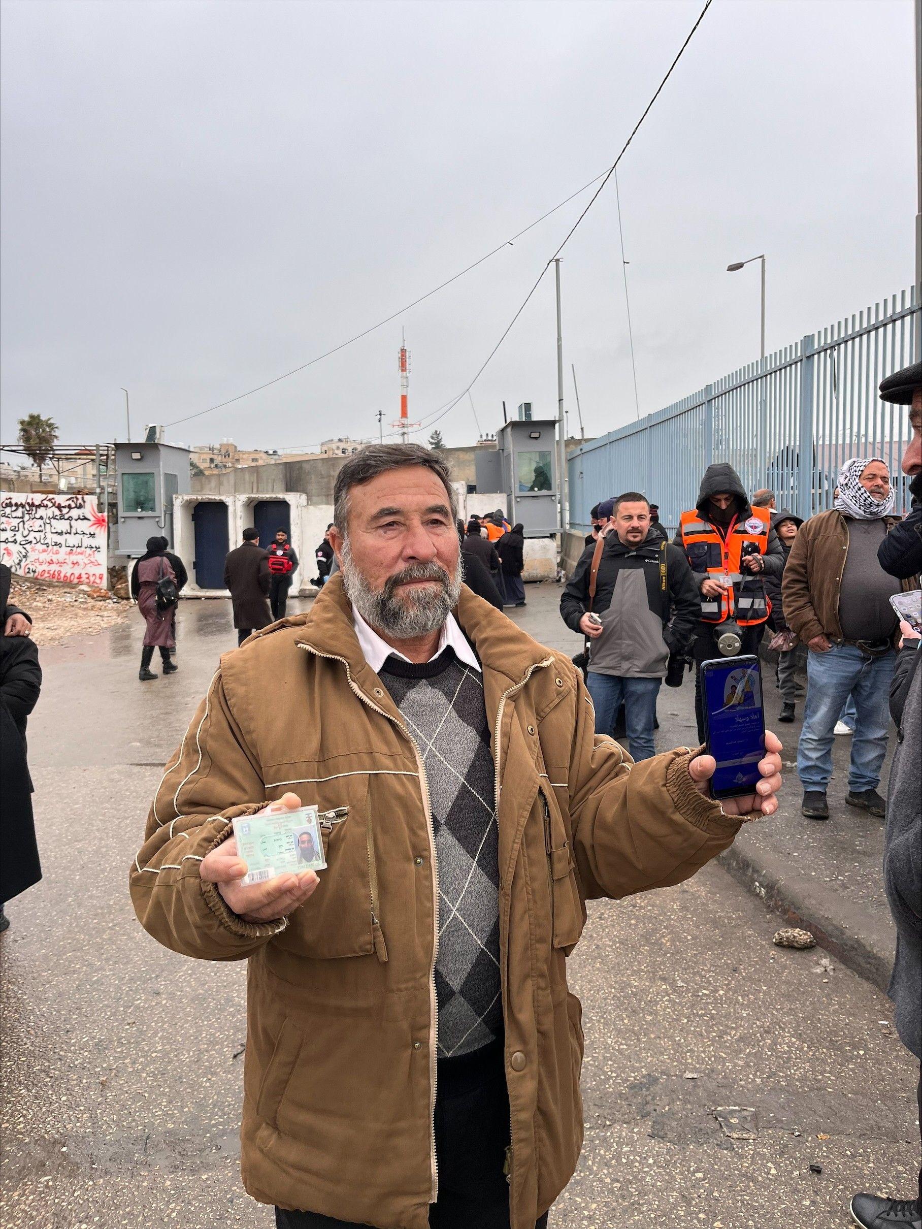 محمود سلامة بشرته بيضاء وشعره ولحيته بلونين رمادي وأبيض. يرفع هويته بيد، وصورة التطبيق على هاتفه النقال بيد أخرى. ويرتدي معطفاً بلون عسلي وقميص شتوي أبيض مقسم مربعات بثلاث ألوان بني وأبيض ولون يميل إلى الرمادي.