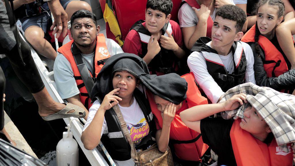 Migrantes embarcando en una lancha en el Caribe panameño