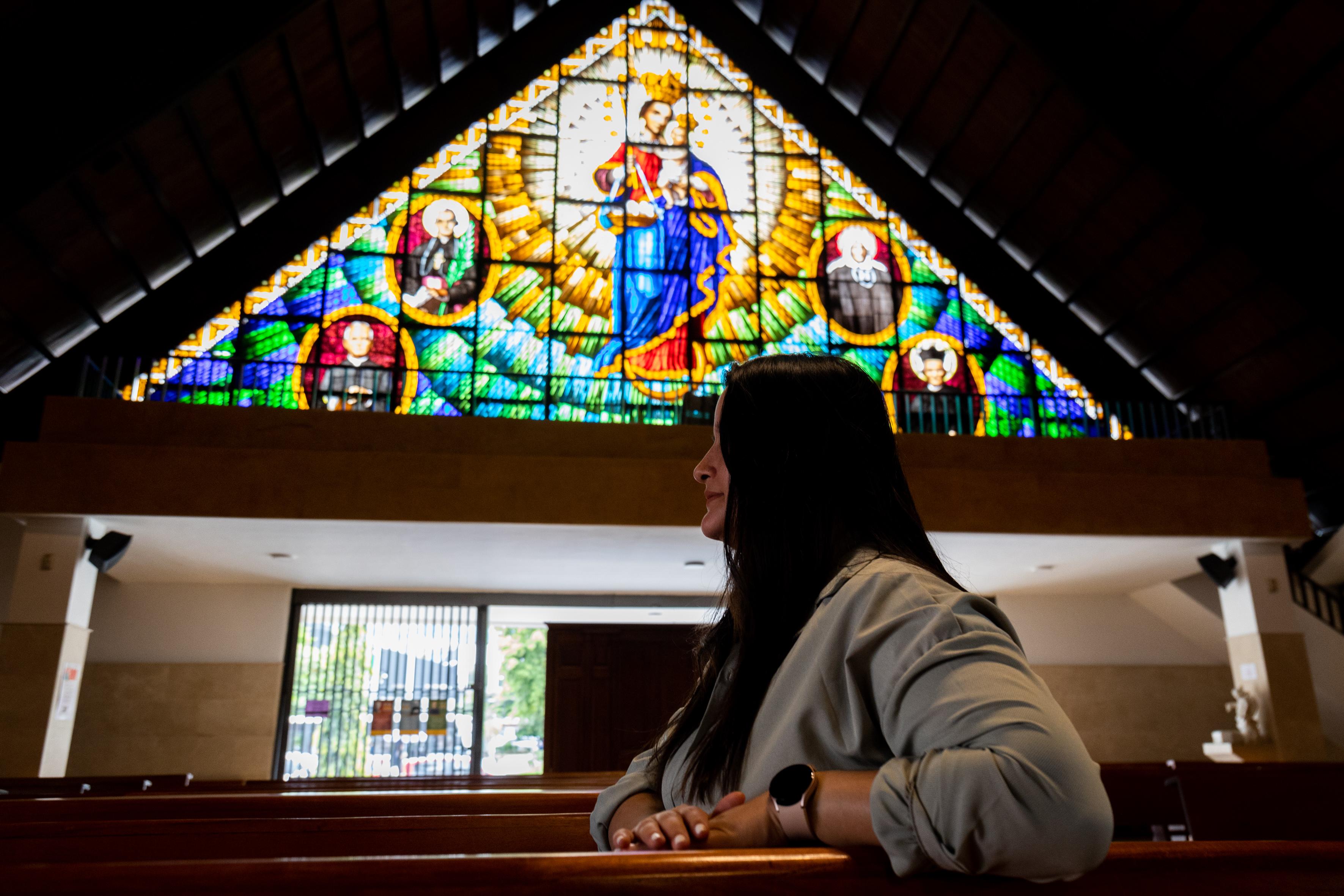Natalia sentada de perfil en un banco de la iglesia de Santa Gertrudis