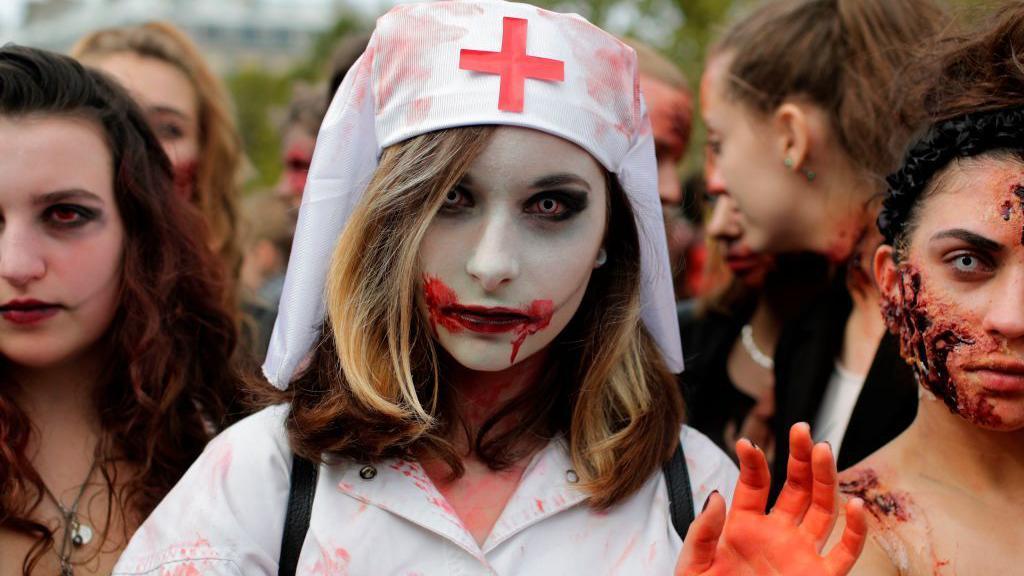 Una mujer disfrazada de enfermera zombi