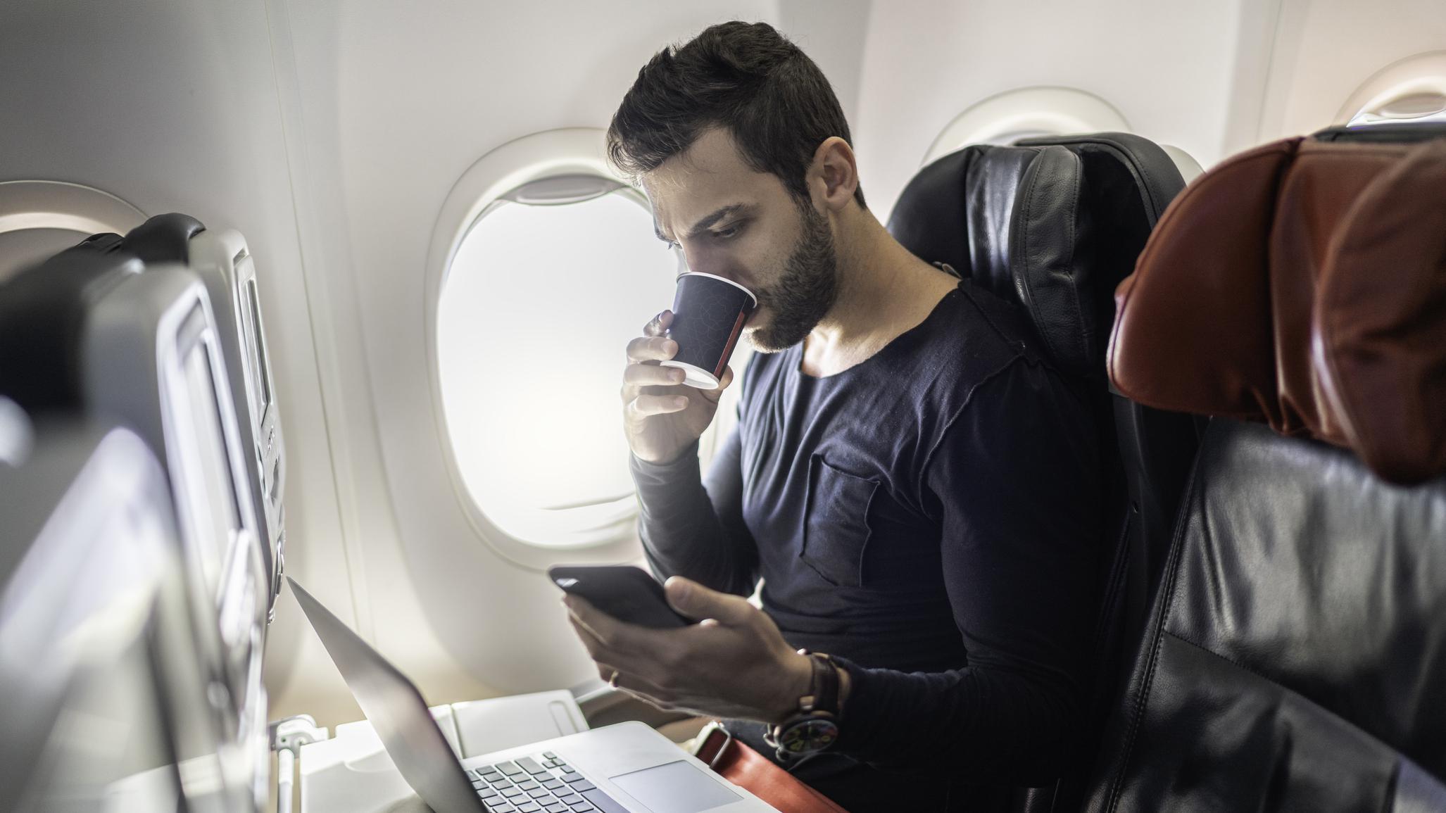 Hombre bebiendo café en el avión