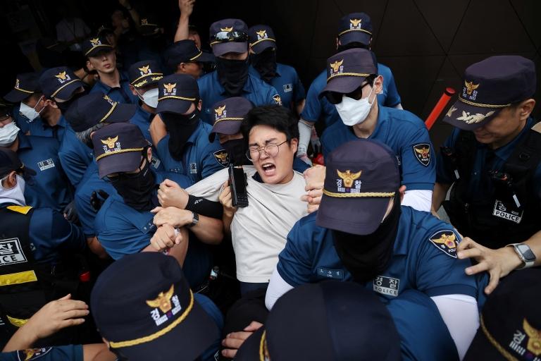 Seorang mahasiswa memaksa masuk ke Kedutaan Besar Jepang di Seoul, Korea Selatan, pada Kamis (24/8), guna memprotes pelepasan air bekas pembangkit listrik tenaga nuklir (PLTN) non-aktif Fukushima ke Samudra Pasifik. (Foto: Reuters)
