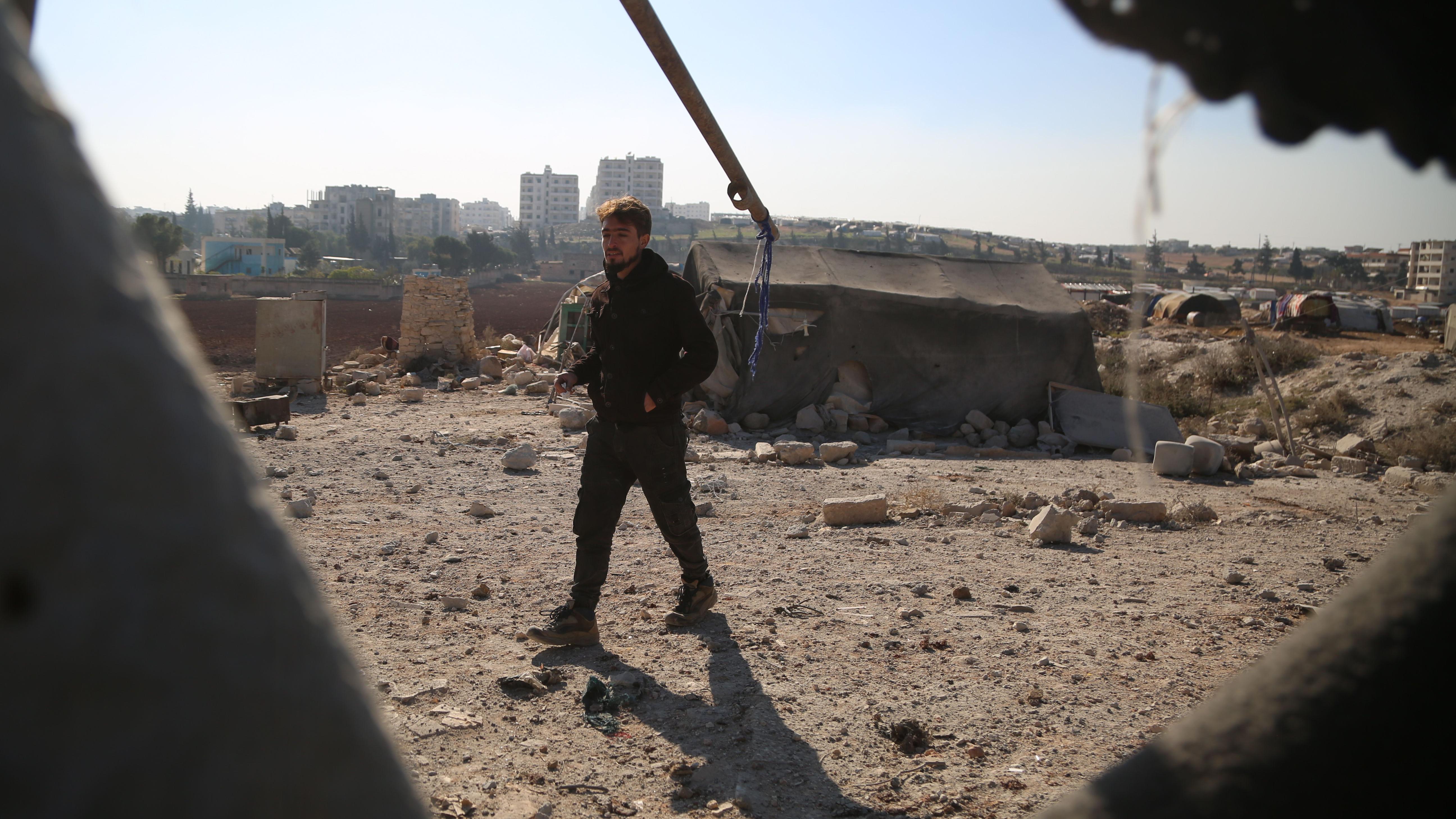 رجل يتفقد الأضرار بعد غارة جوية على مخيم للاجئين في حي الجامعة في مدينة إدلب، شمال سوريا،