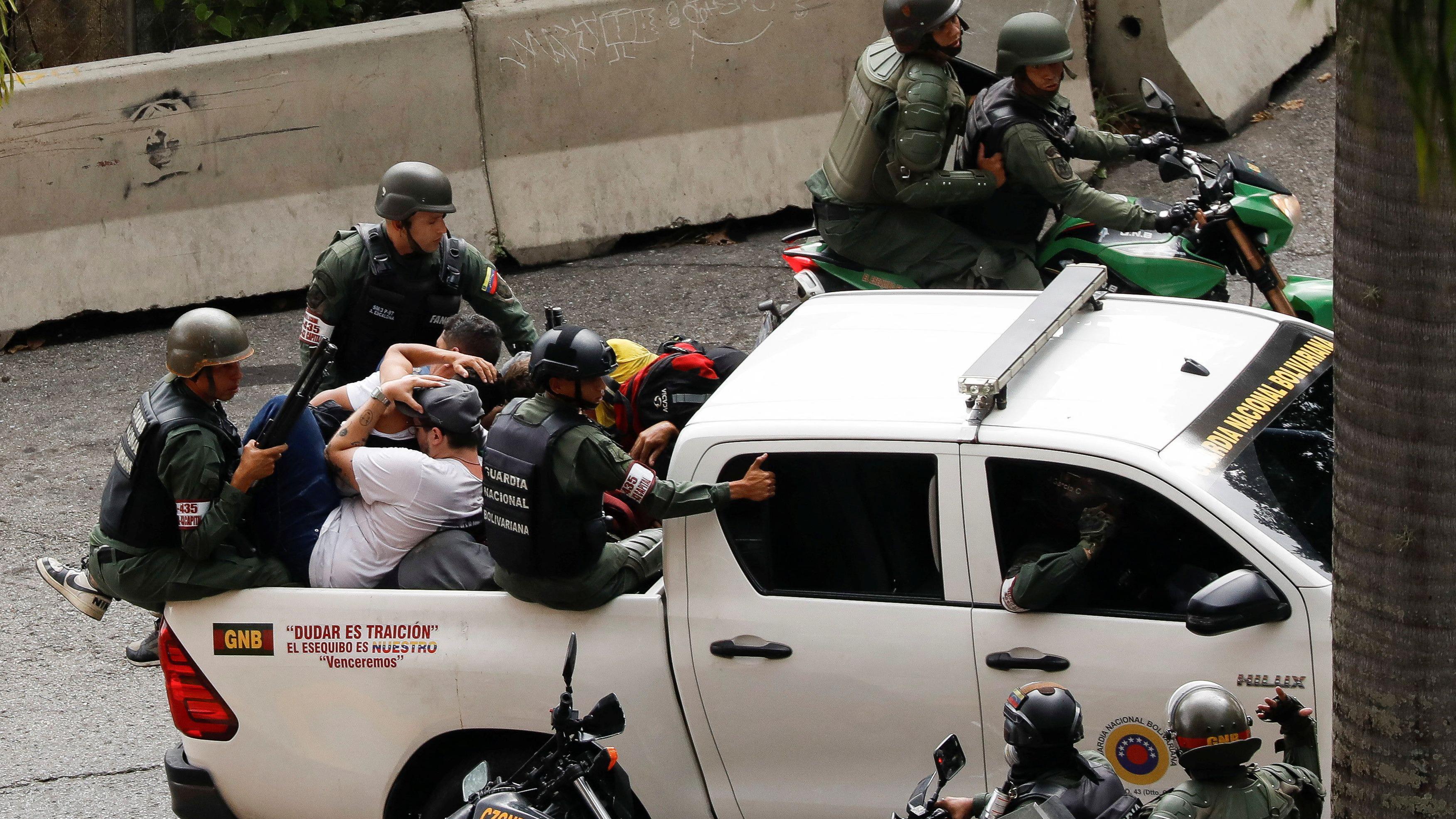 A imagem mostra uma caminhonete branca com ao menos dois civis e três policiais na caçamba.