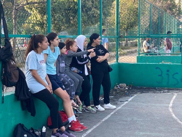 Un grupo de mujeres en ropa deportiva en una cancha de baloncesto. 