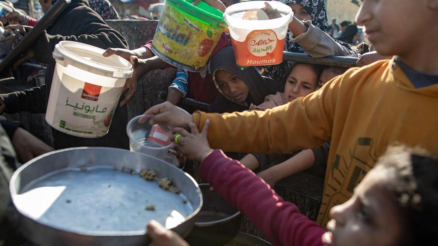 أطفال يحاولون الحصول على طعام في غزة