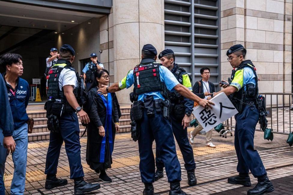 La policía le confiscó una pancarta de protesta a un familiar de uno de los acusados ​​cuando salía del tribunal.

