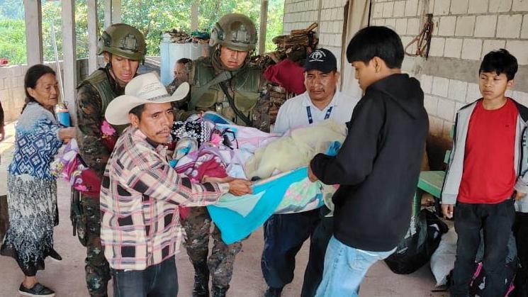 Personas cargan a un enfermo que llega de Chiapas a Guatemala
