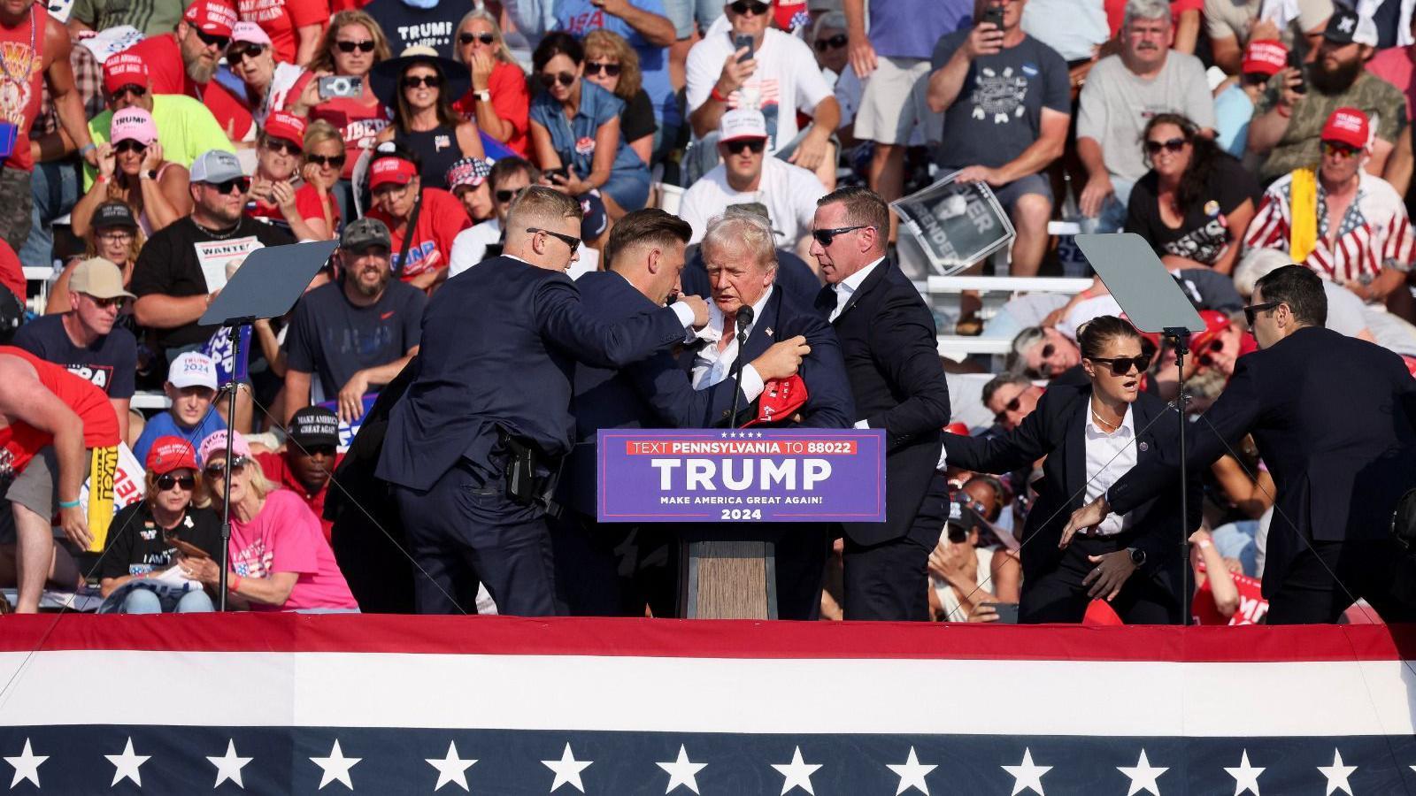 Trump sendo retirado do palco após tiros 