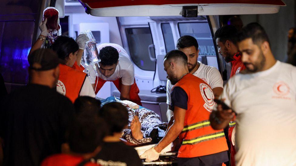 Uma pessoa ferida sendo carregada em uma maca para uma ambulância em Beirute.  