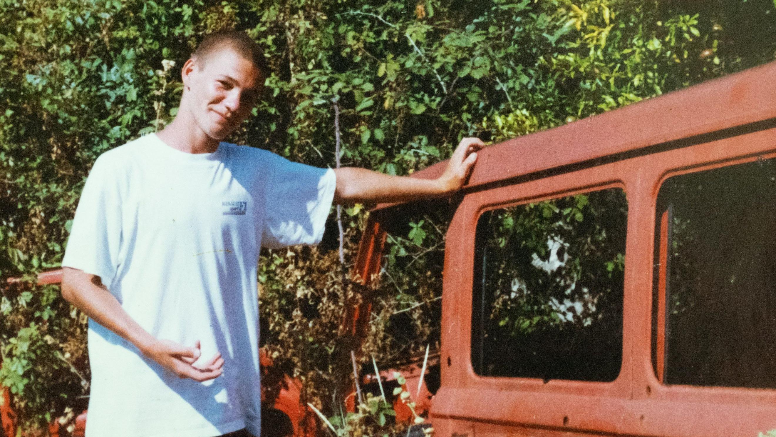 Foto familiar de Ivan Mastorovic apoyado en los restos de un auto oxidado. 