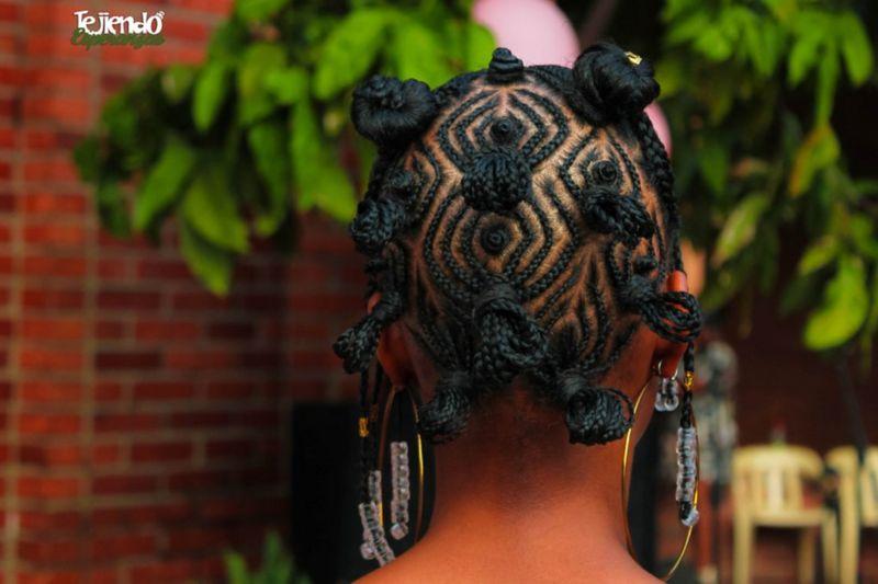 Mulher de costas usando penteado afro com tranças