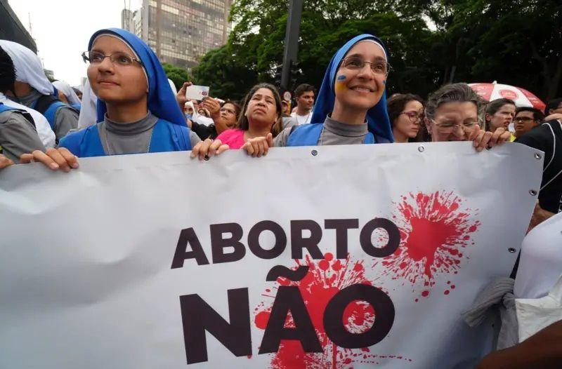 Protesto no Brasil contra o aborto, freiras segurando faixa escrito 'aborto não'