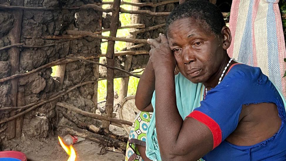 Uma mulher descansando a cabeça nas mãos, com um olhar triste