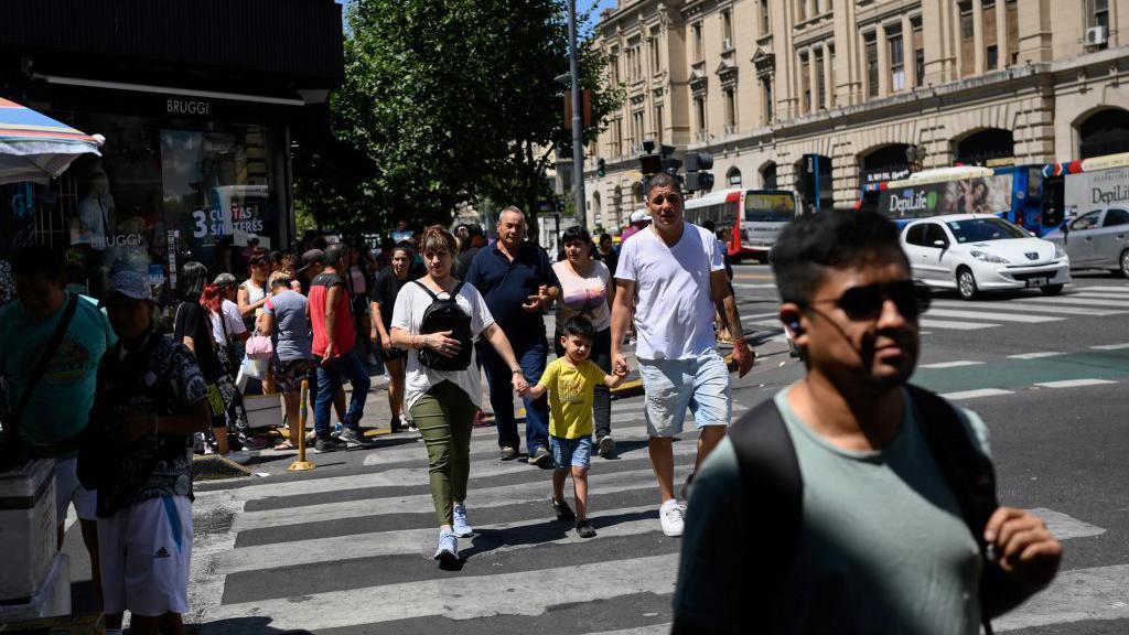 Pessoas atravessando uma rua em Buenos Aires