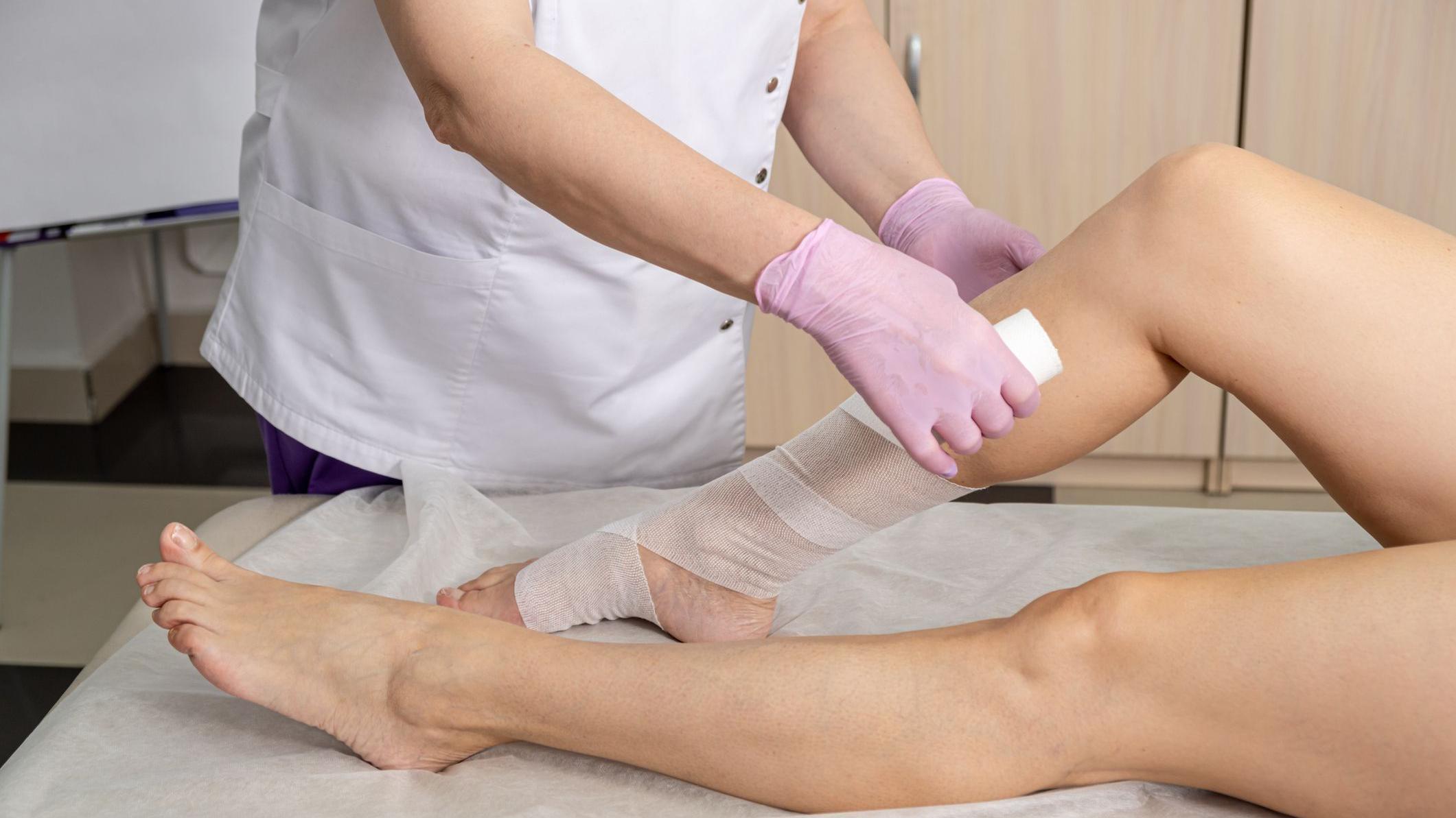 Un especialista da un masaje en las piernas a una mujer. 
