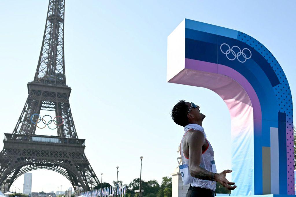 Daniel Pintado, um homem branco, comemorando ao lado da Torre Eiffel