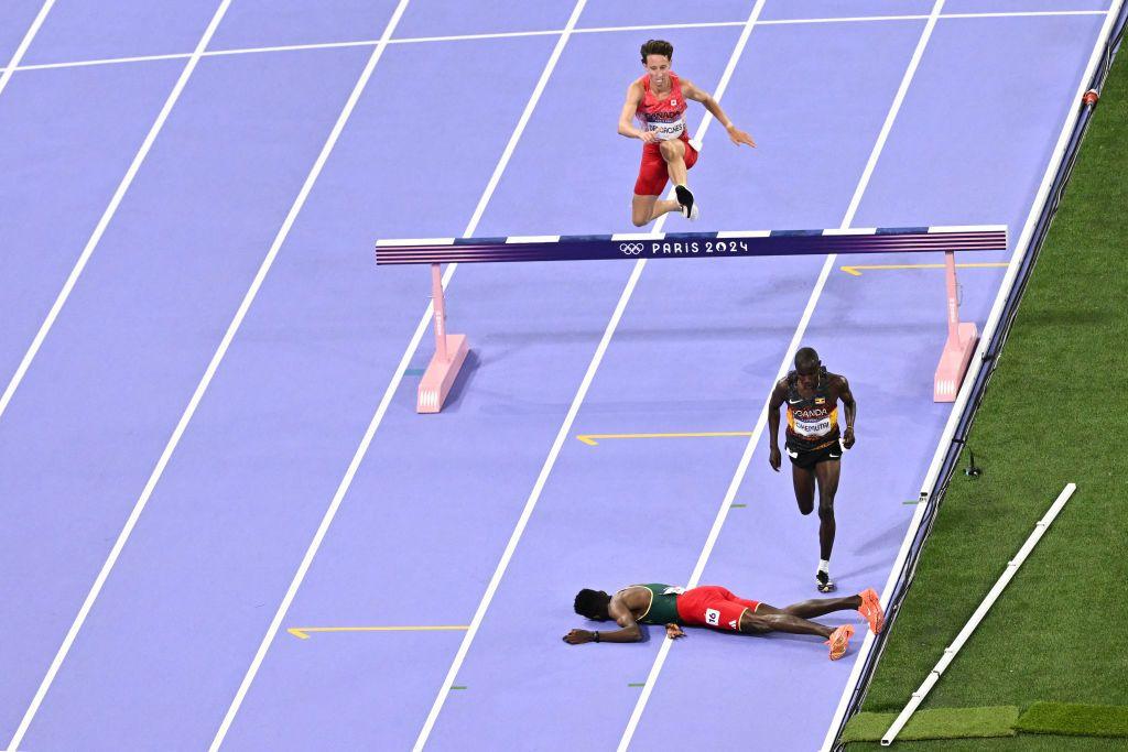 Lamecha Girma tirado en el suelo de la pista de atletismo en el Stade de France.