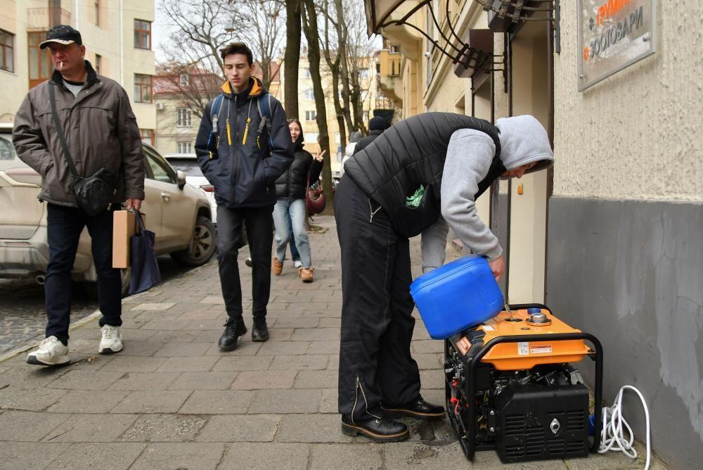 Un hombre pone combustible a un generador eléctrico en Lviv, Ucrania