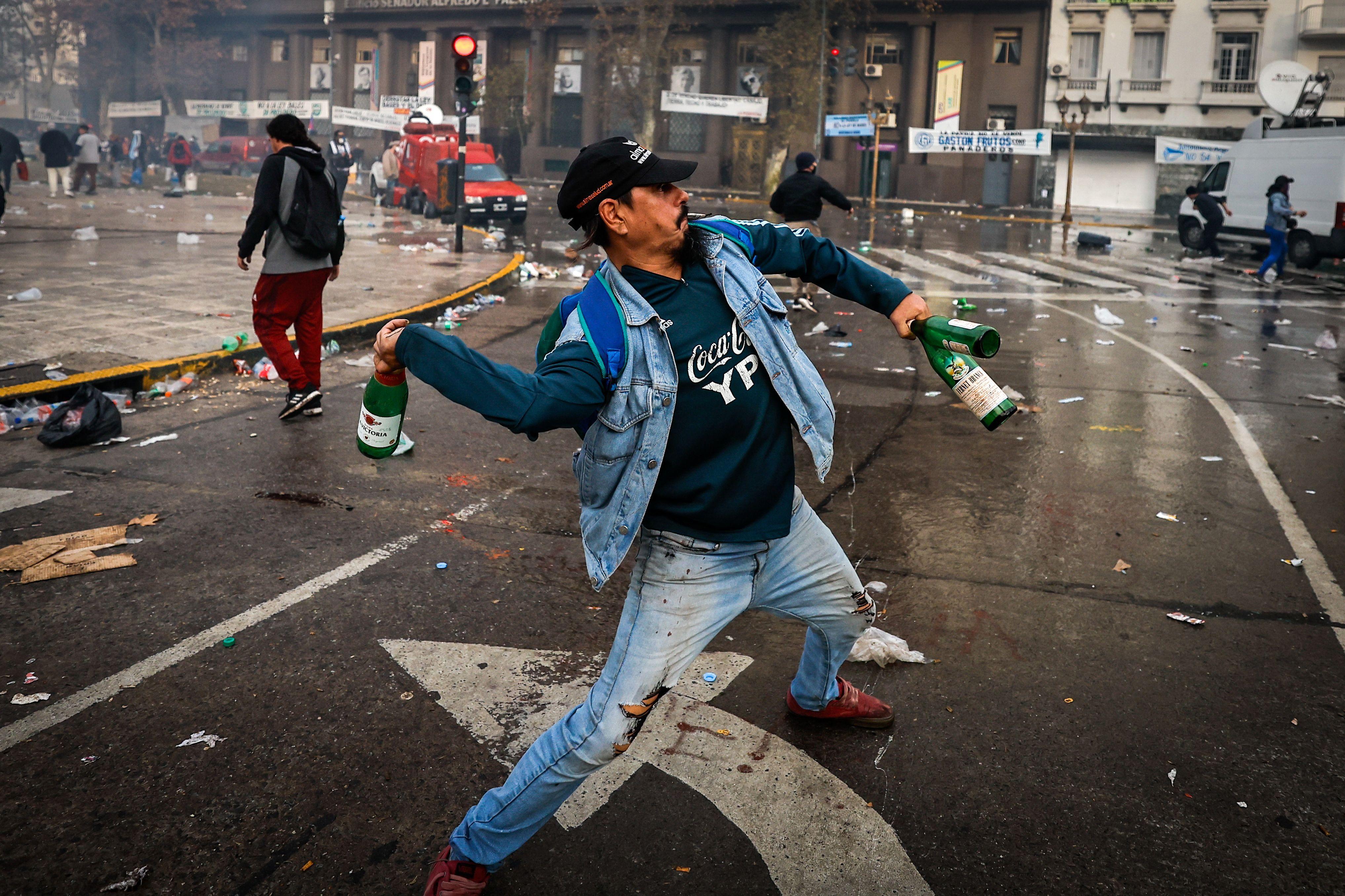 Un hombre lanza una botella en las protestas en Buenos Aires. 