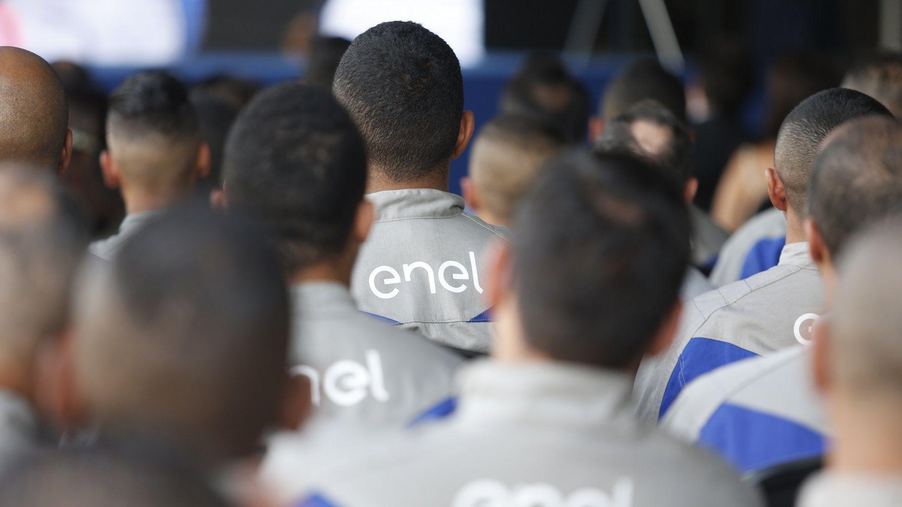 Grupo de funcionários da Enel de costas, vestidos com o uniforme da empresa