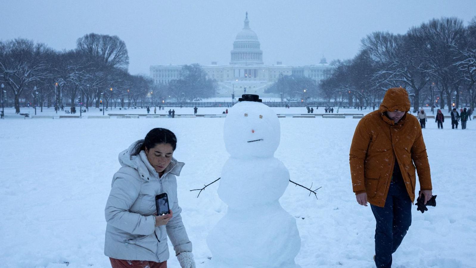 Duas pessoas montando um boneco de neve em Washington