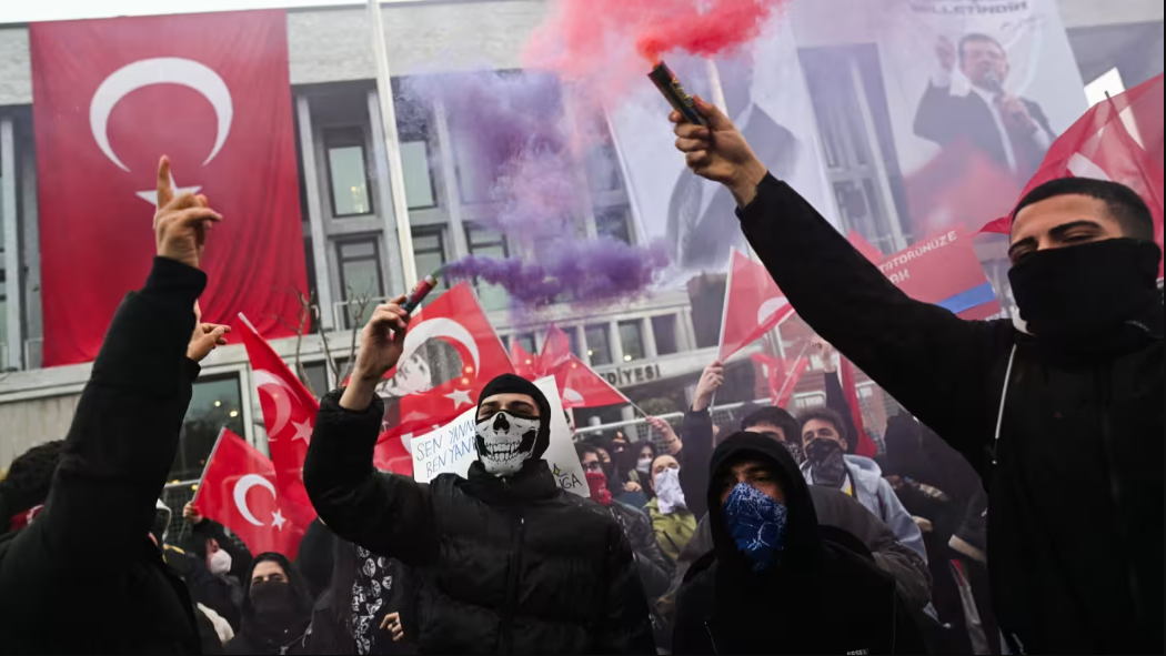 متظاهرون في تركيا يحملون الأعلام التركية ويغطون وجوههم