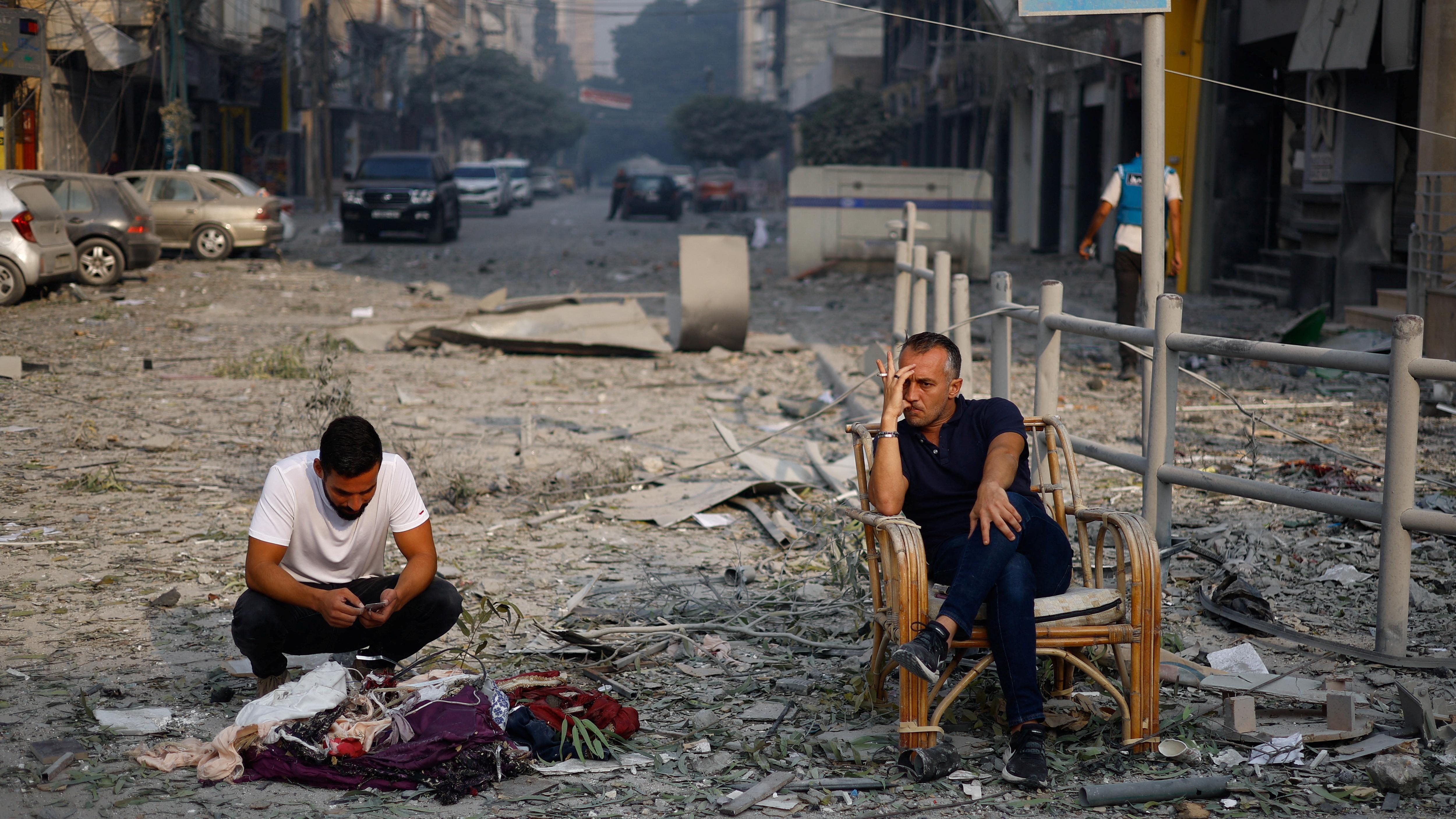 شخصان يجلسان بعد أن تم تدمير منزلهما