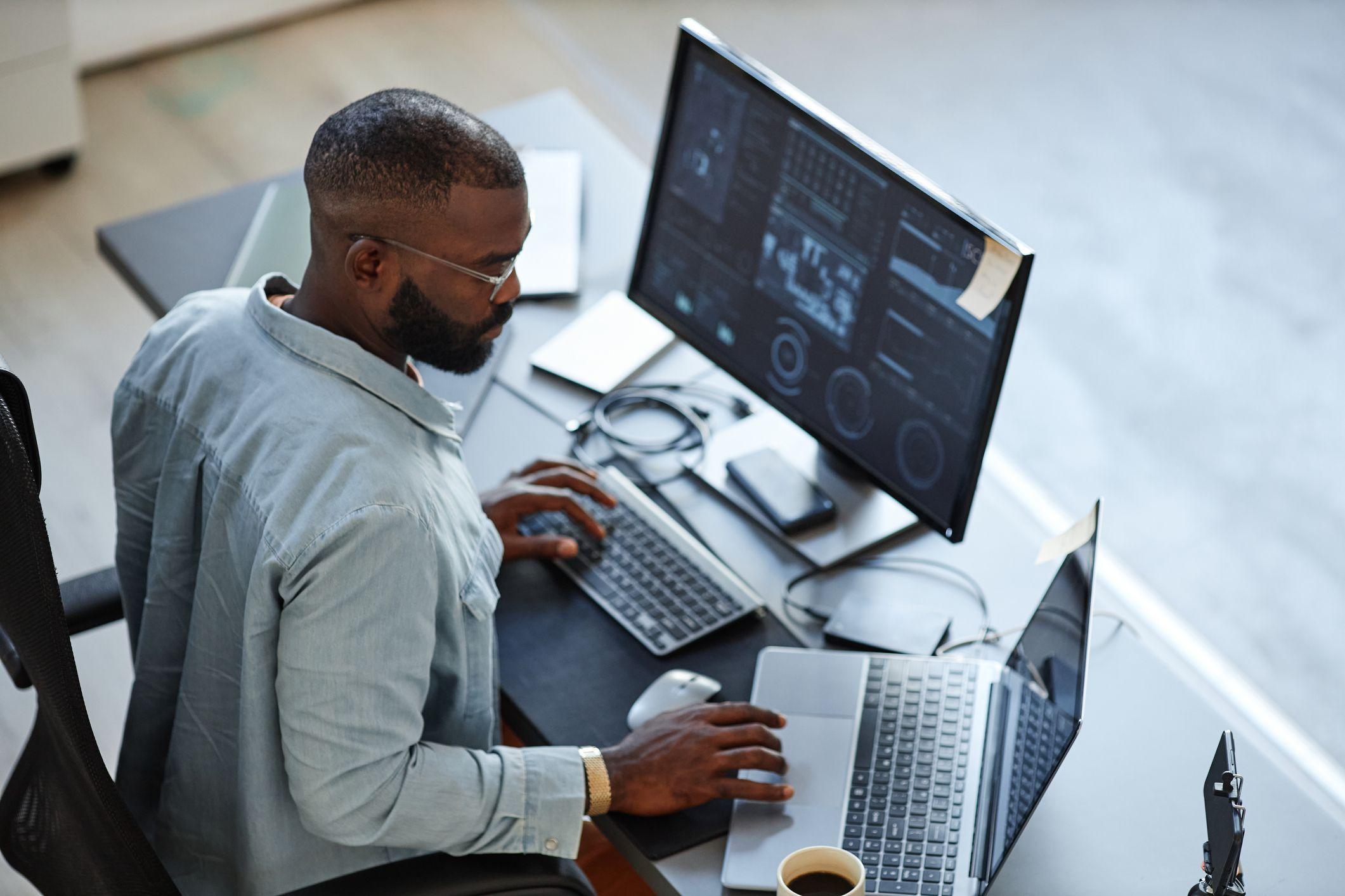 Profissional em frente a 2 telas de computador