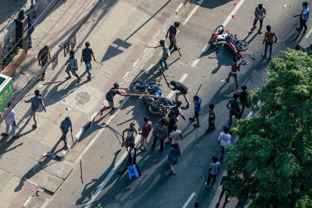 Kendaraan dirusak oleh kerumunan demonstran.